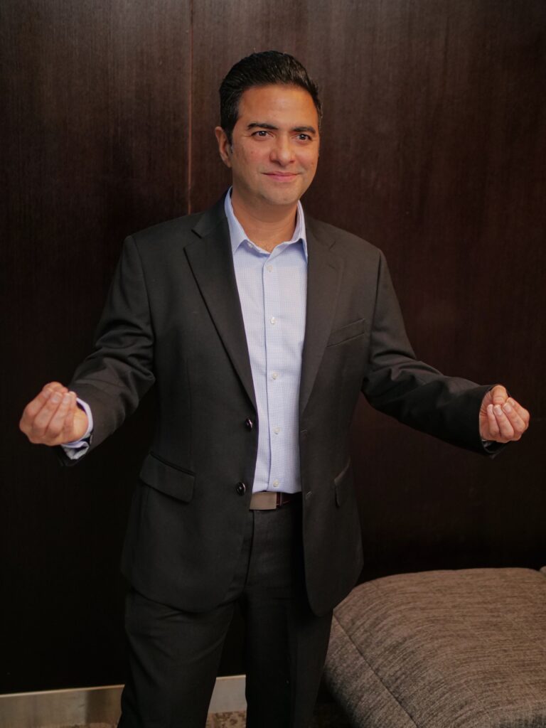 Businessman in suit smiling indoors.