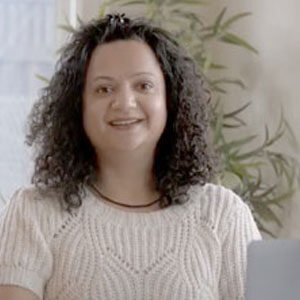 Smiling woman with curly hair at home office.