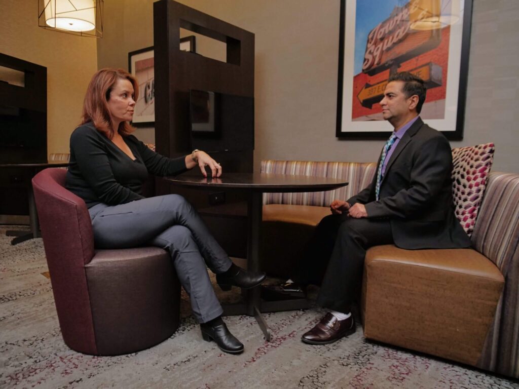 Two people having a discussion in a hotel lobby.