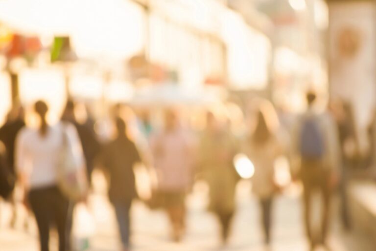 Blurred urban street scene with walking people.