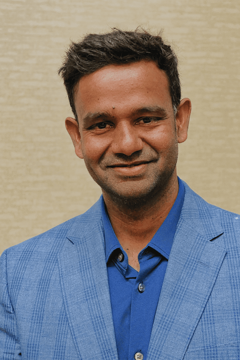 Man in blue blazer smiling.