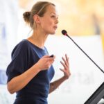 Woman giving a speech at a podium.