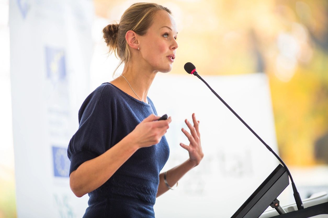 Woman giving a speech at a podium.